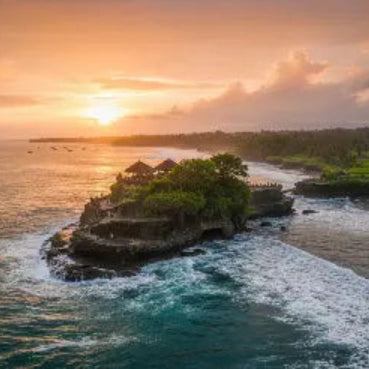 esim Bali Indonesia Sunset over a temple on an island in the middle of the ocean with waves crashing around
