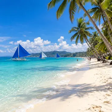 esim data trip Philippines Tropical beach scene with white sand, turquoise water, palm trees, and three blue-sailed traditional boats on the ocean under a bright blue sky